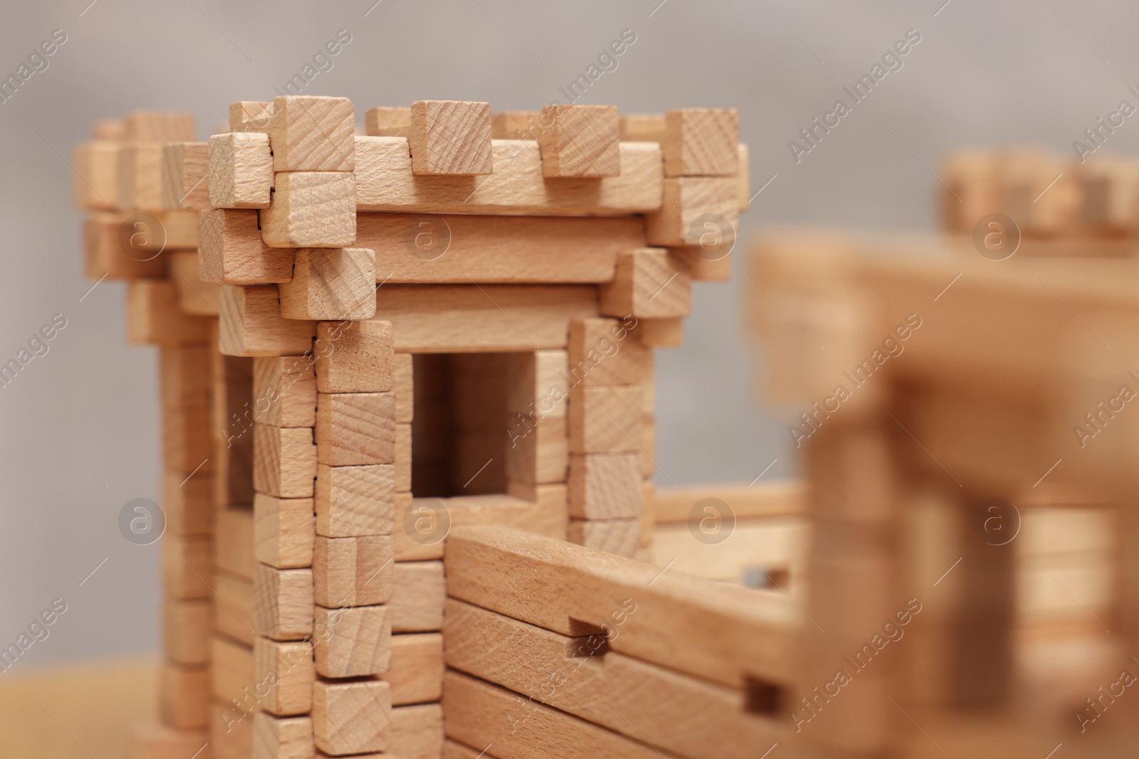 Photo of Wooden fortress against grey background, closeup. Children's toy