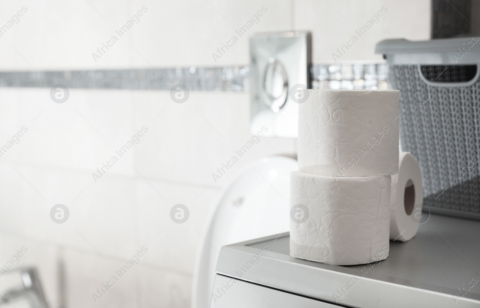 Photo of Toilet paper rolls on table in bathroom. Space for text