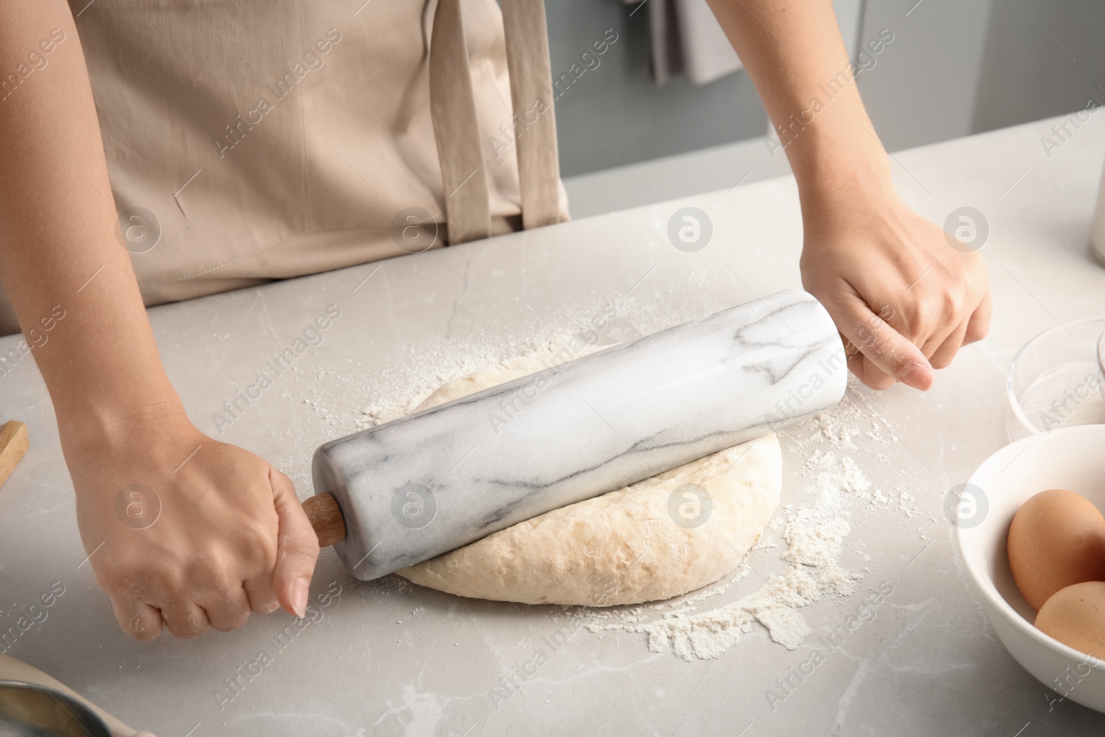 Photo of Woman rolling dough for pastry on table