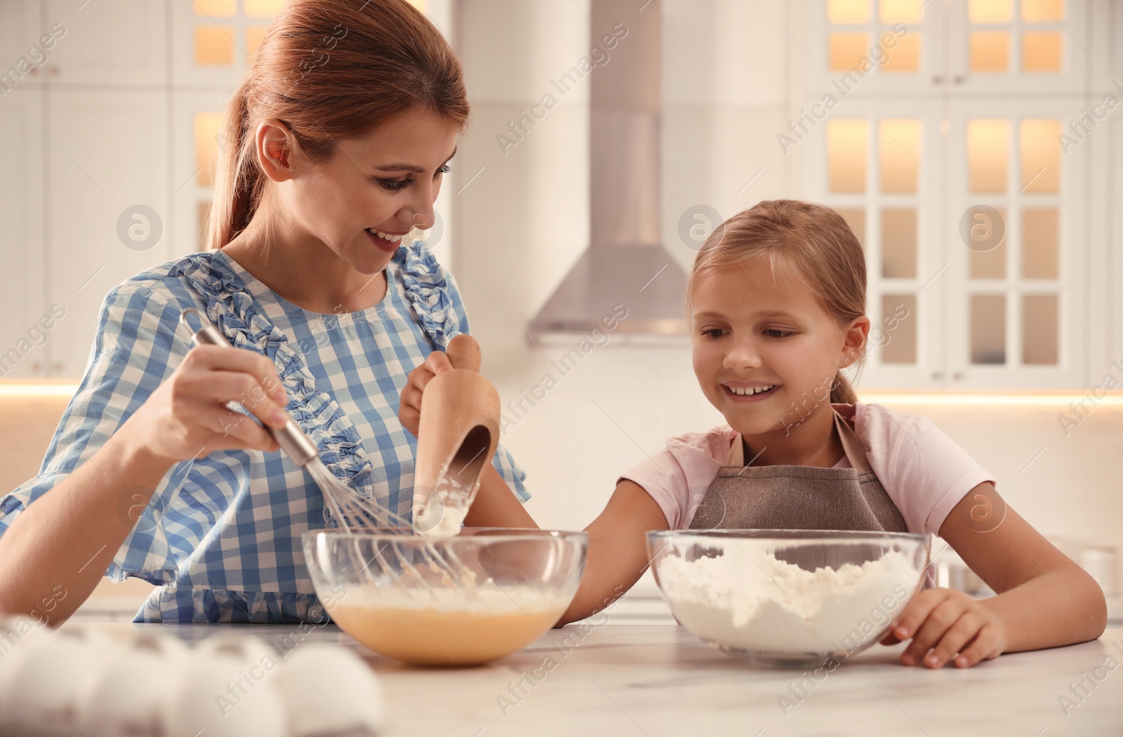 Photo of Mother and daughter making dough together in kitchen