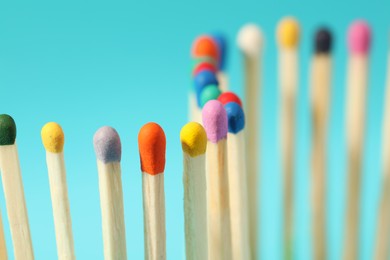 Photo of Matches with colorful heads on light blue background, closeup