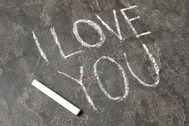 Photo of Text I Love You and chalk piece on grey stone background