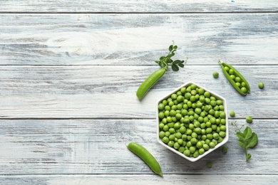 Photo of Flat lay composition with green peas on wooden background