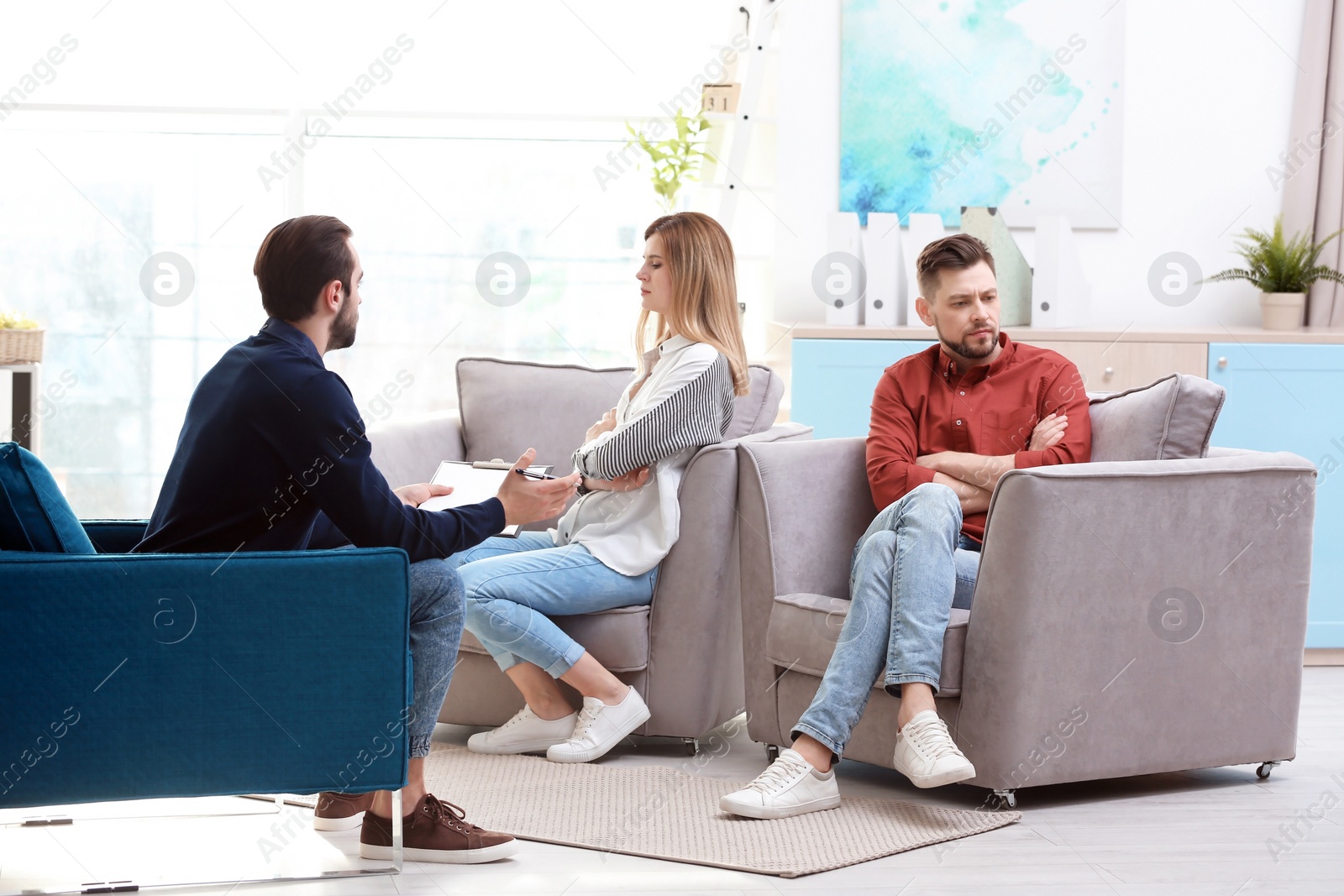 Photo of Family psychologist working with young couple in office