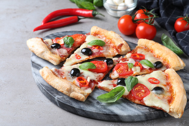 Photo of Pieces of delicious pizza Diablo on grey table