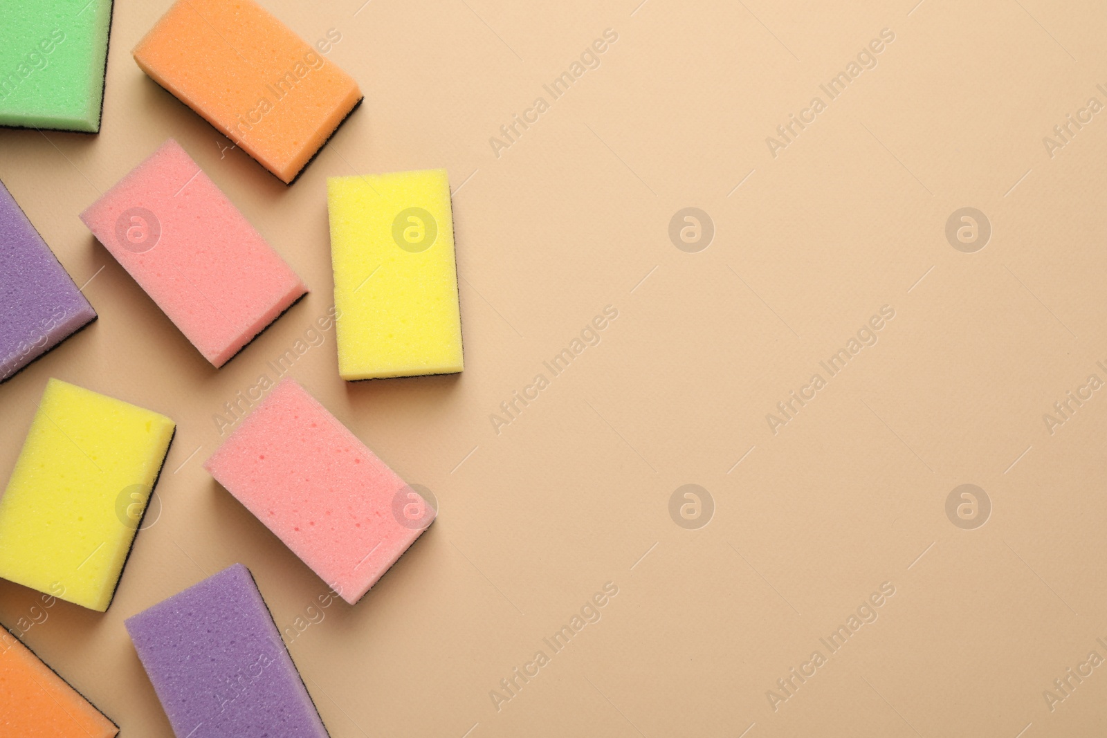 Photo of New sponges on beige background, flat lay. Space for text