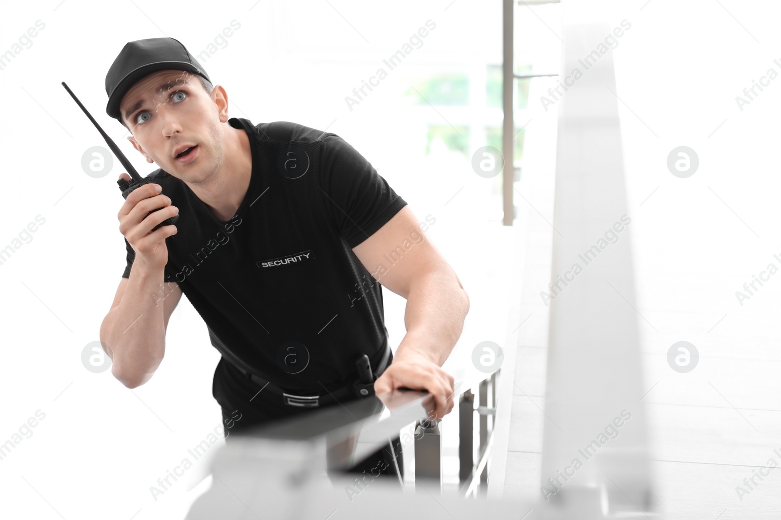 Photo of Male security guard with portable radio transmitter indoors