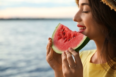 Photo of Beautiful young woman with watermelon near river, closeup