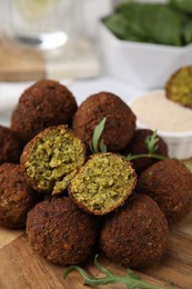 Photo of Delicious falafel balls and arugula on table