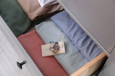 Beautiful scented wax sachet and clothes in dresser drawer, closeup