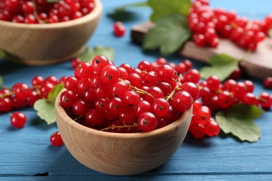 Photo of Delicious red currants on blue wooden table