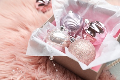 Beautiful Christmas baubles in box on pink faux fur