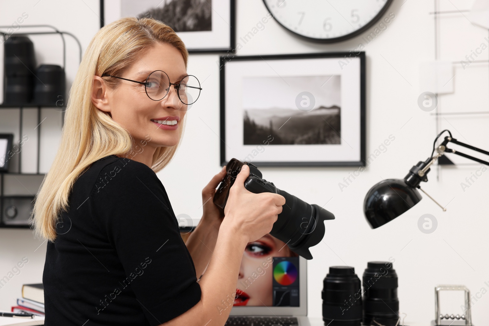 Photo of Professional photographer with modern digital camera in office