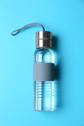 Sport bottle with water on color background