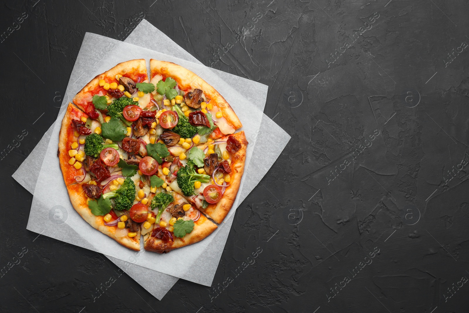 Photo of Delicious vegetarian pizza with mushrooms, vegetables and parsley on black table, top view. Space for text