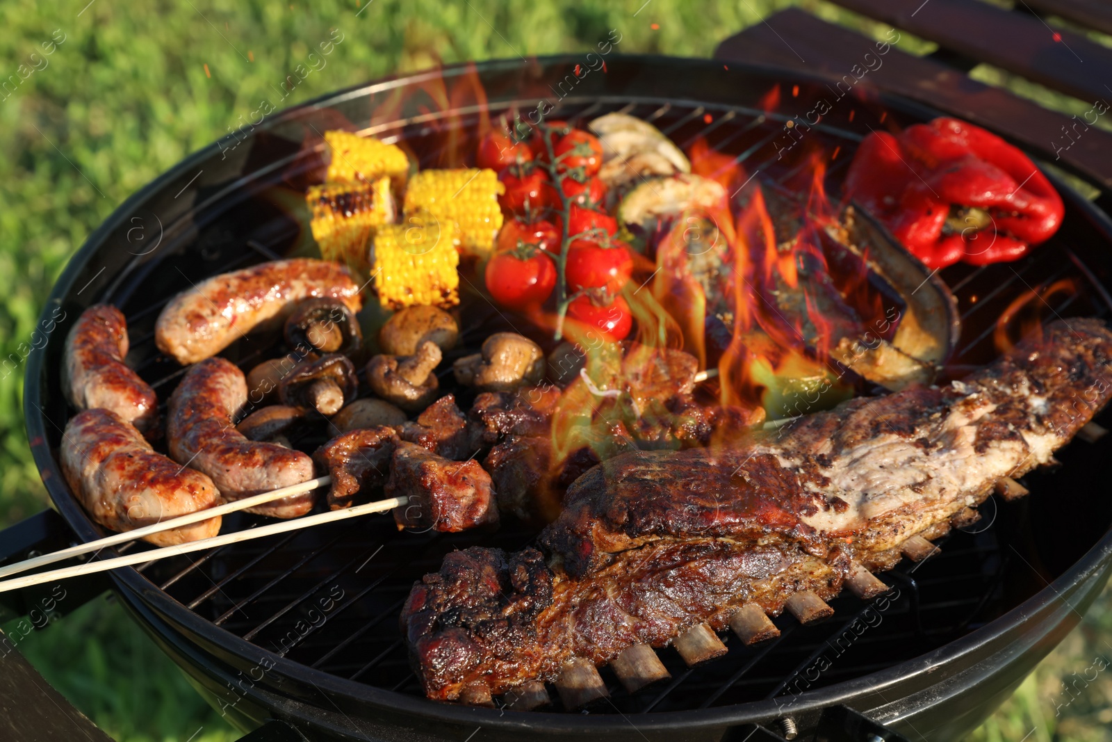 Photo of Tasty meat and vegetables on barbecue grill outdoors