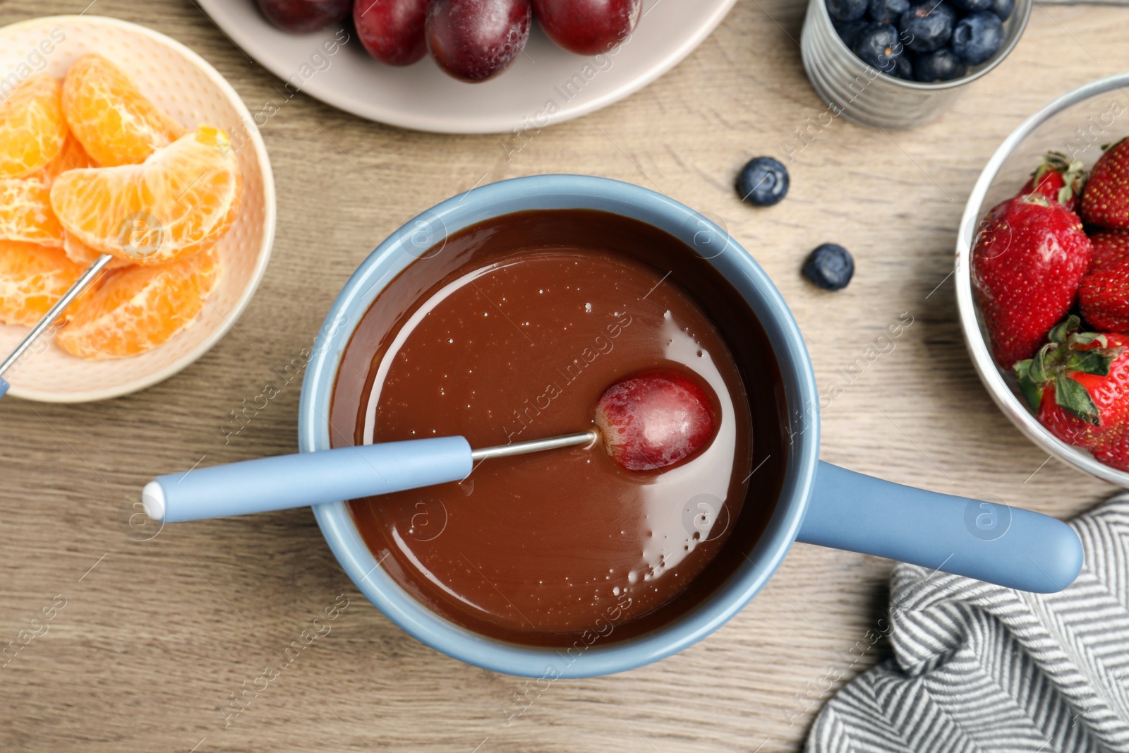 Photo of Flat lay composition with chocolate fondue on wooden background