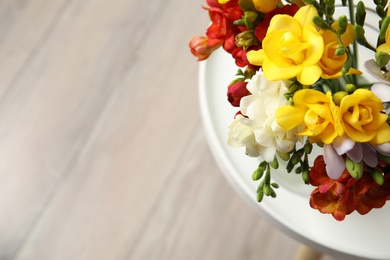 Photo of Beautiful spring freesia flowers on table, view from above. Space for text
