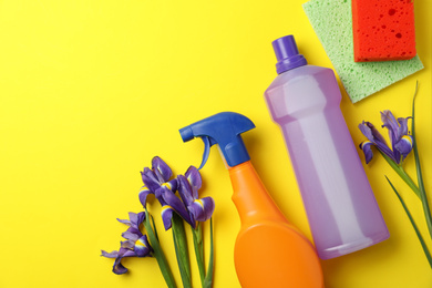 Photo of Composition with spring flowers and cleaning supplies on yellow background, flat lay. Space for text