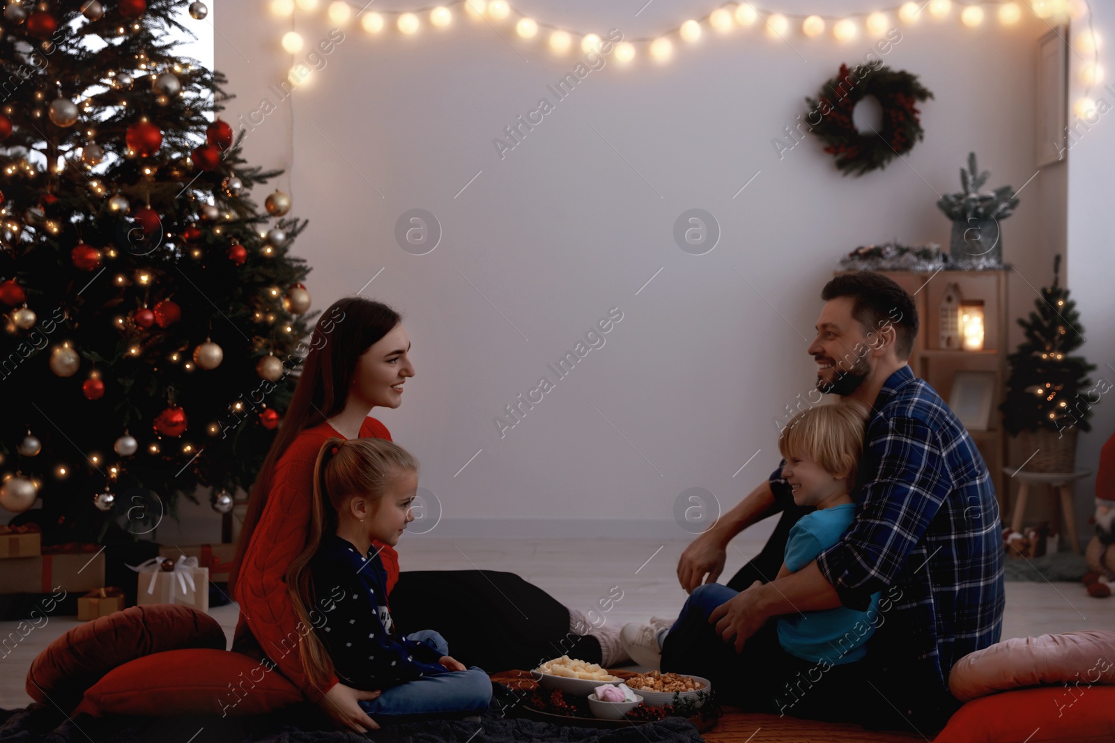 Photo of Family spending time together at TV area in cosy room. Christmas atmosphere