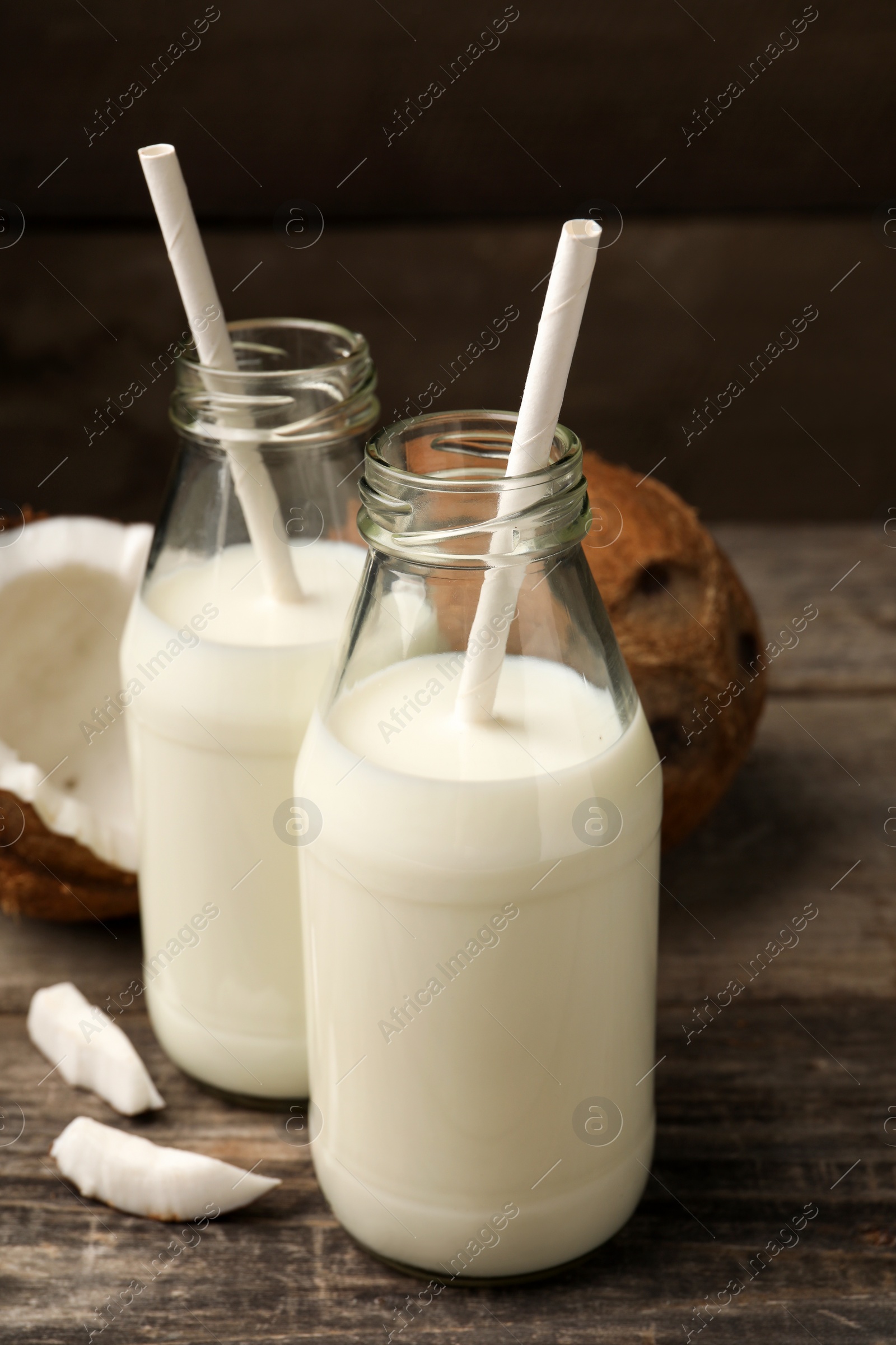 Photo of Delicious vegan milk and coconuts on wooden table