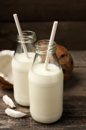 Delicious vegan milk and coconuts on wooden table