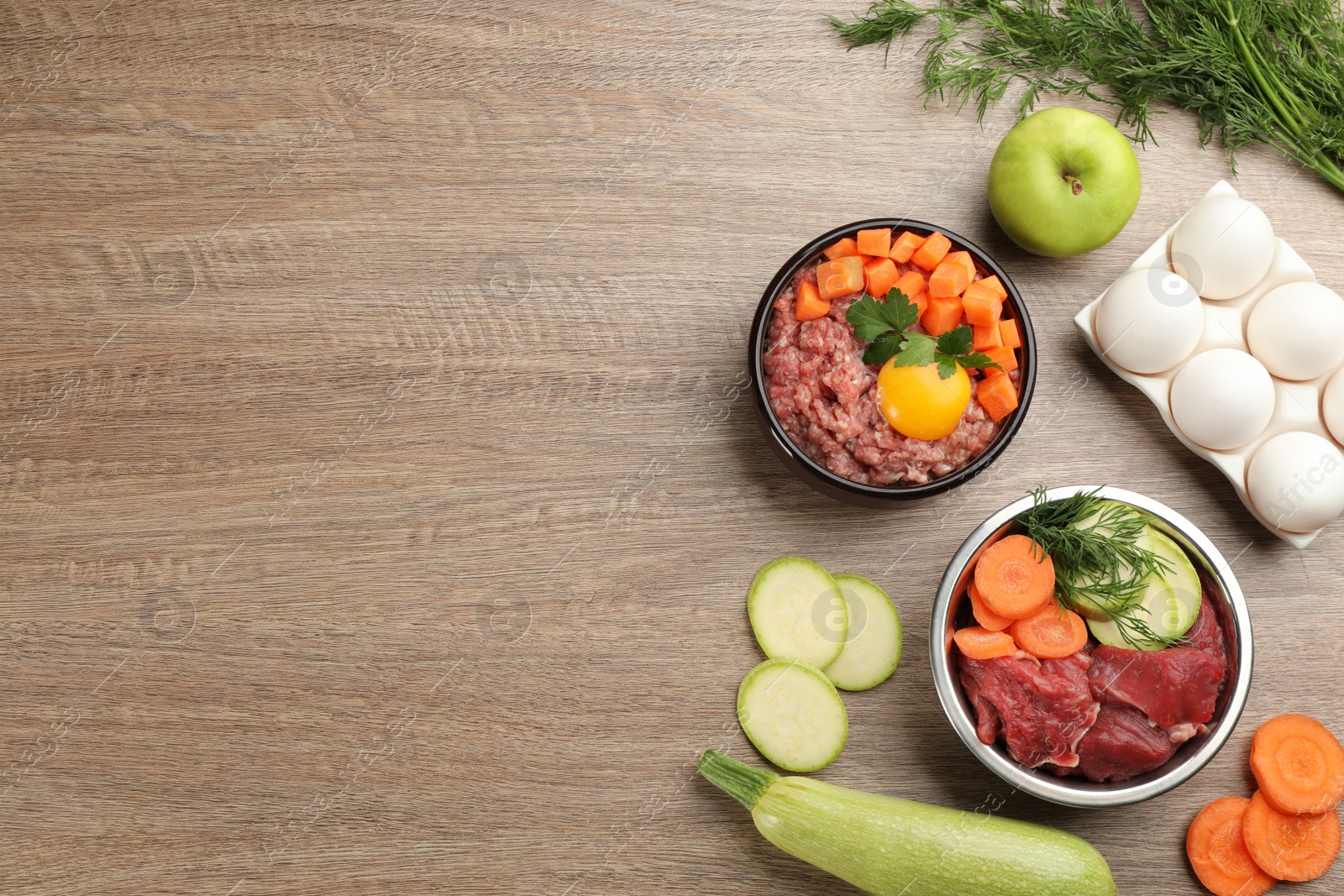 Photo of Pet food and natural ingredients on wooden table, flat lay. Space for text