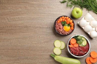 Pet food and natural ingredients on wooden table, flat lay. Space for text