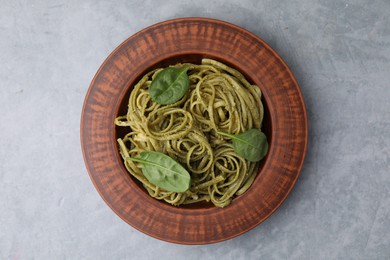 Photo of Tasty pasta with spinach on grey table, top view