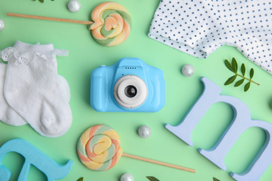 Flat lay composition with toy camera on light green background. Future photographer