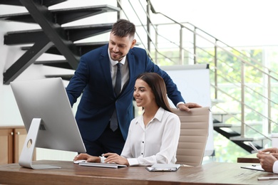 Man helping his colleague with work in office