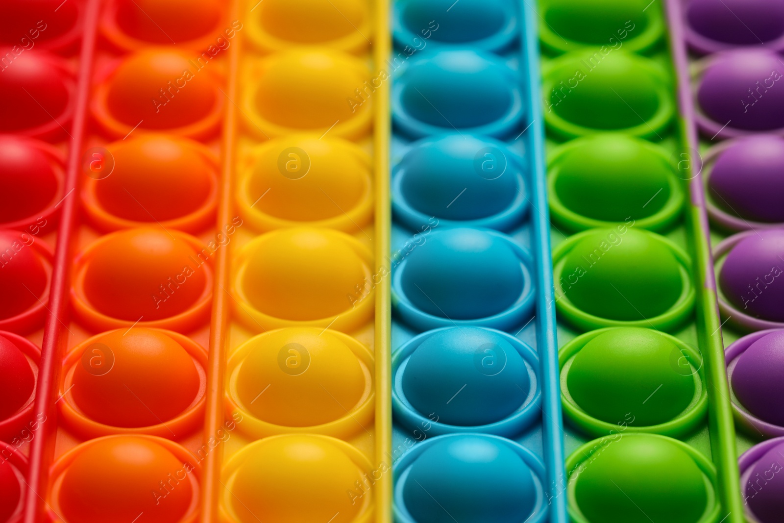 Photo of Rainbow pop it fidget toy as background, closeup