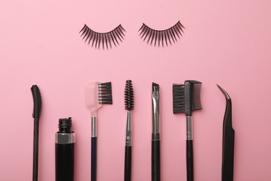 Flat lay composition of professional makeup tools and false eyelashes on color background