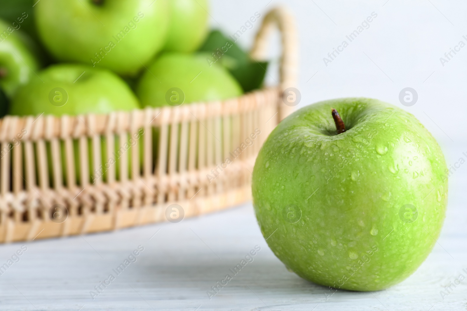 Photo of Juicy green apple on white wooden table, closeup