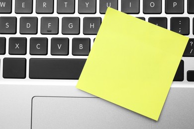 Photo of Empty sticky note on laptop, top view. Space for design
