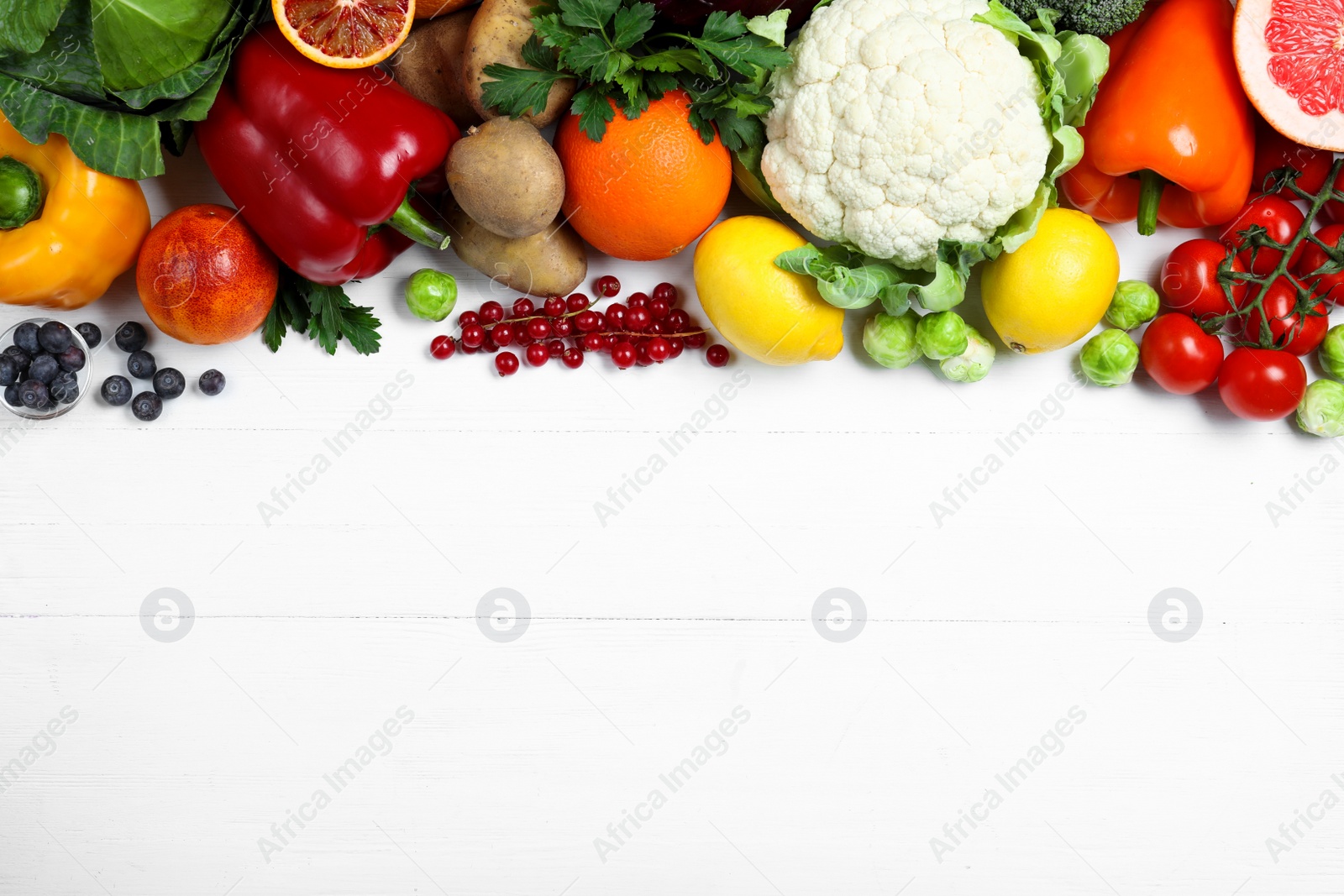 Photo of Fresh products rich in vitamin C on white wooden table, flat lay. Space for text