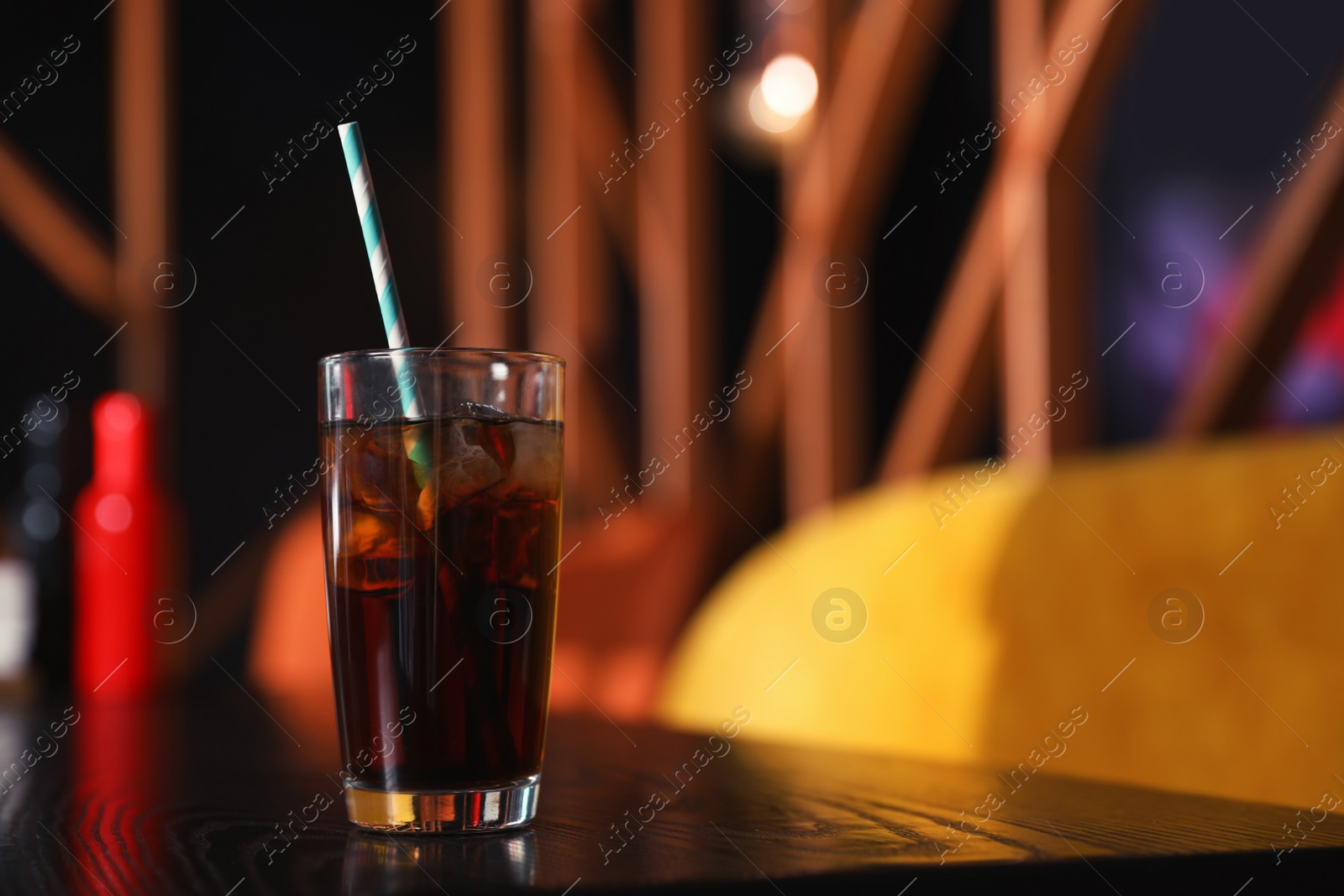 Photo of Glass of refreshing cola with ice on table indoors. Space for text