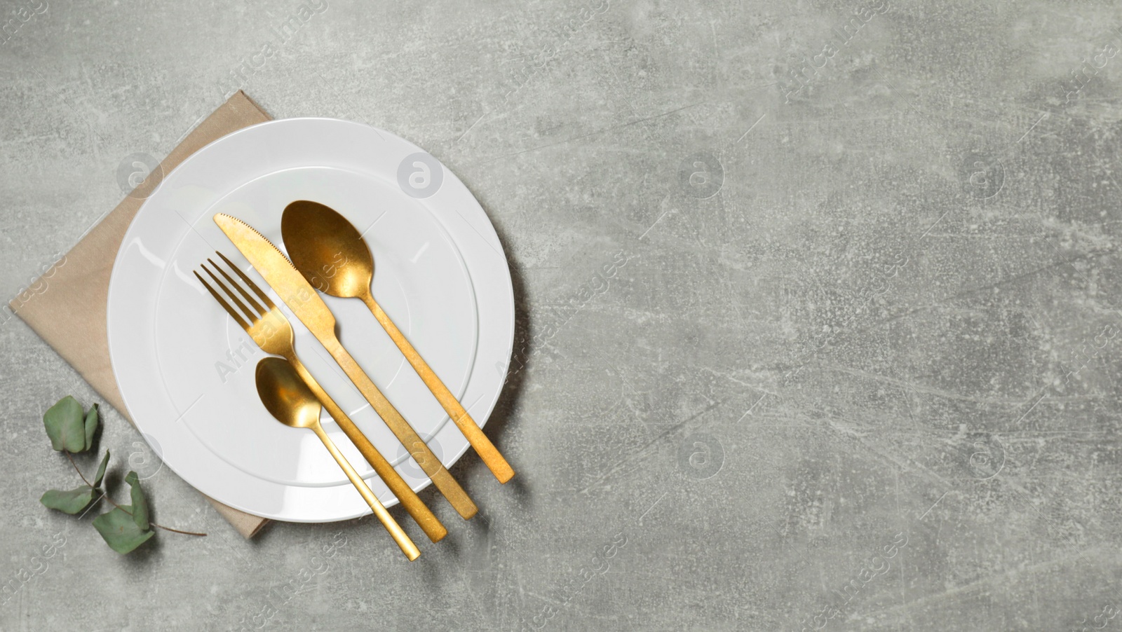 Photo of Stylish setting with elegant cutlery on grey table, top view. Space for text