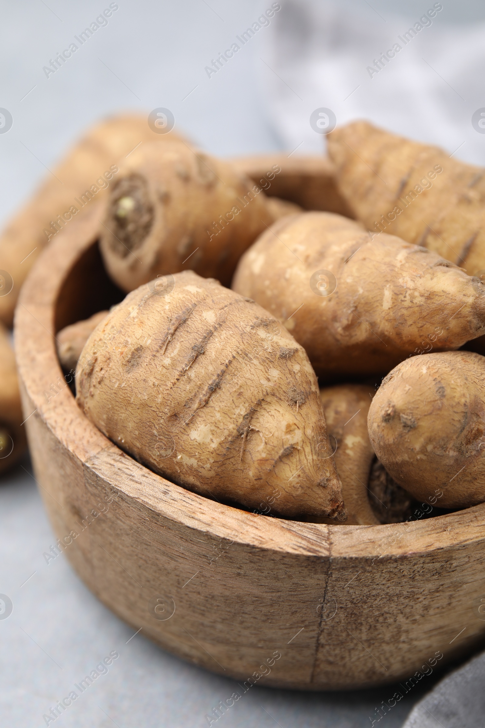 Photo of Tubers of turnip rooted chervil on light grey table, closeup