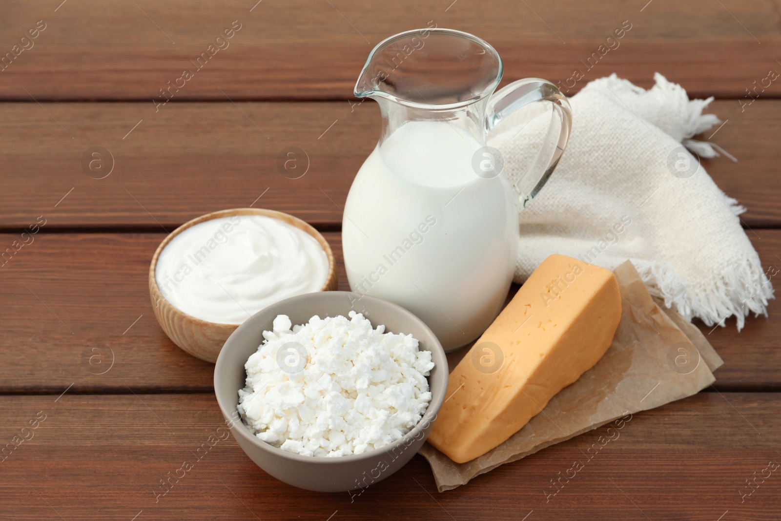 Photo of Tasty cottage cheese and other fresh dairy products on wooden table