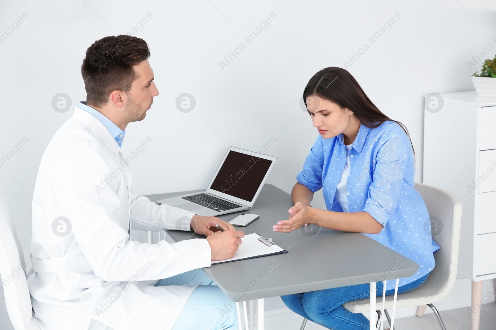 Photo of Depressed young woman having appointment with psychologist in office