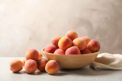 Photo of Delicious ripe peaches on table against grey background