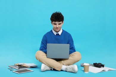 Photo of Portrait of student with laptop and stationery on light blue background
