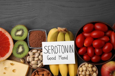 Photo of Many different products and card with phrase Serotonin Good Mood on grey wooden table, flat lay. Natural antidepressants