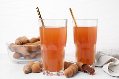 Tamarind juice and fresh fruits on white table