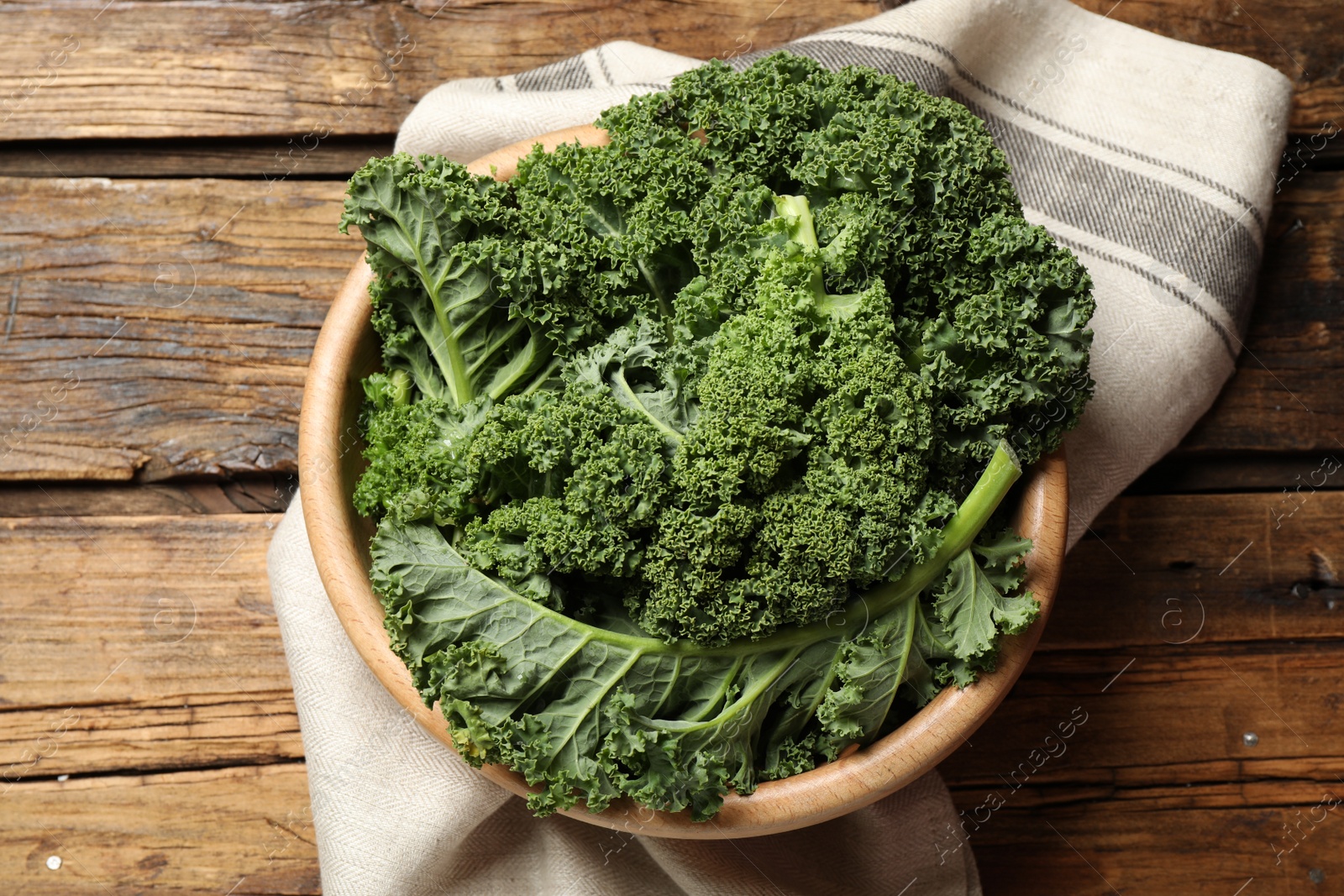 Photo of Fresh kale leaves on wooden table, top view