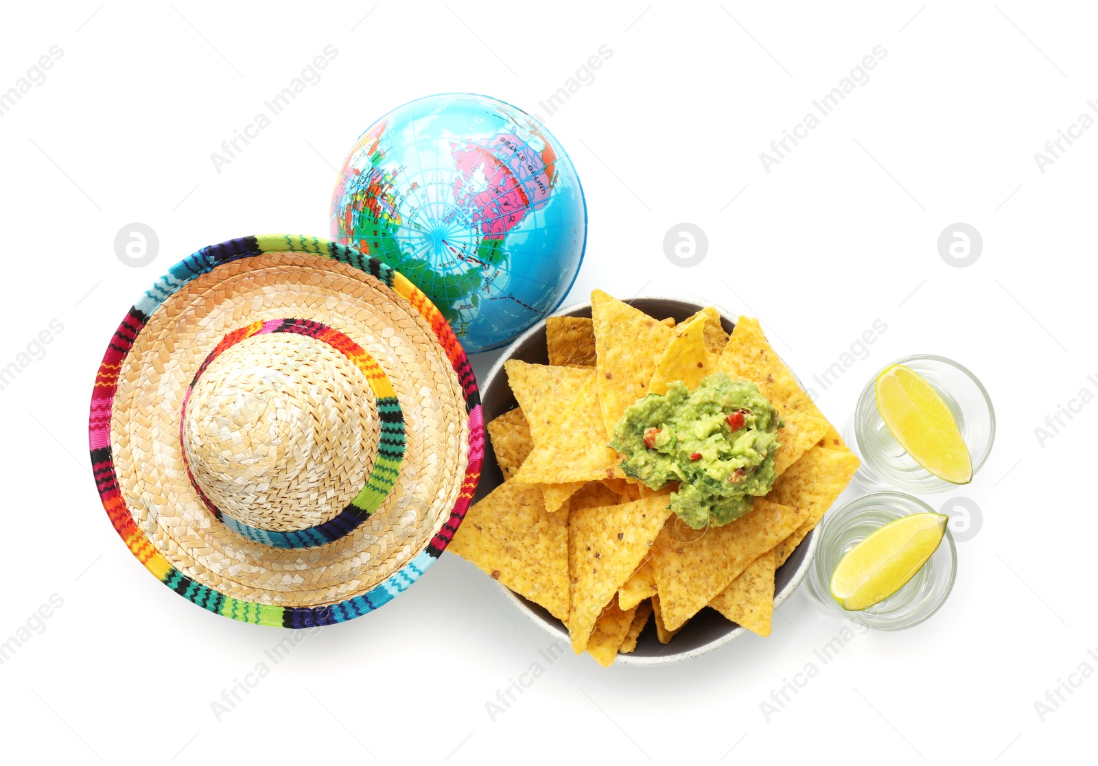 Photo of Mexican sombrero hat, tequila with lime, globe, nachos chips and guacamole in bowl isolated on white, top view