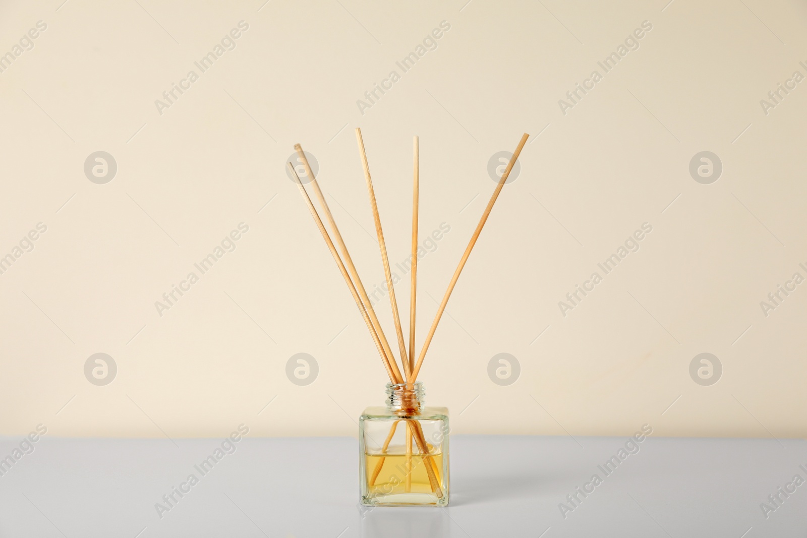 Photo of Aromatic reed air freshener on white table indoors
