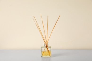 Photo of Aromatic reed air freshener on white table indoors