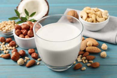 Vegan milk and different nuts on light blue wooden table